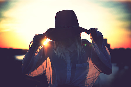 woman holding brown hat thumbnail