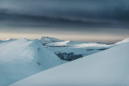 snow capped mountains under gray clouds thumbnail