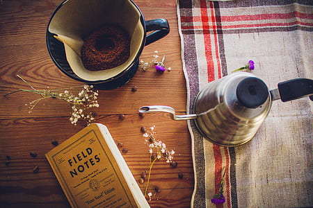 white and blue ceramic coffee cup near Field Notes book thumbnail