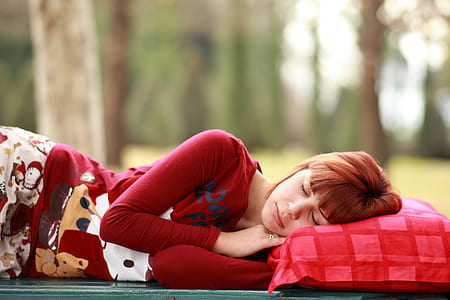 woman in red sweatshirt sleeping outdoor during daytime thumbnail