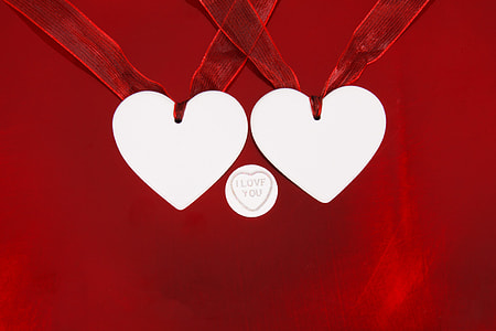 two white heart pendant with i love you text in middle having red background thumbnail