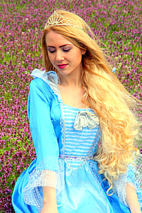 woman wearing teal long-sleeved gown and tiara on purple flower field thumbnail