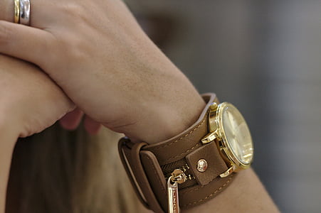 person wearing round gold-colored watch thumbnail