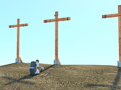 man kneeling on floor in front of cross in mountain thumbnail