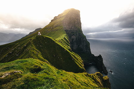calm body of water surrounding mountain thumbnail
