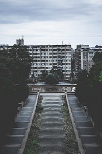 photo of concrete buildings beside trrees thumbnail