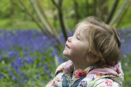 baby in white and pink floral jacket smiling at daytime thumbnail