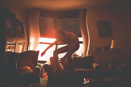 man jumping beside sofa thumbnail