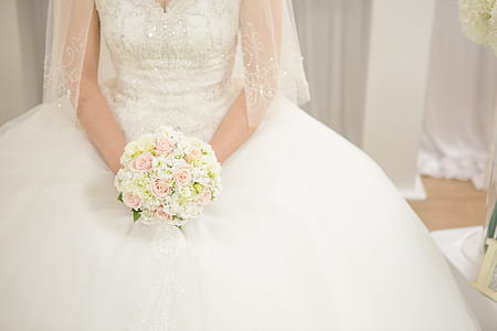 woman wearing white wedding gown holding flower thumbnail
