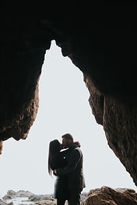photography of man and woman kissing in cave at daytime thumbnail