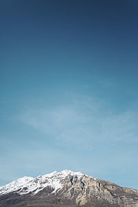 landscape photo of gray mountain covered with snow under blue sky thumbnail