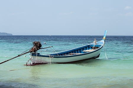 white and blue wooden canoe on body of water thumbnail