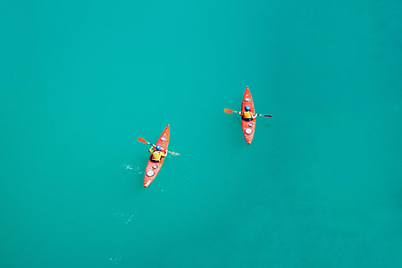 two person riding on red kayak with paddles thumbnail
