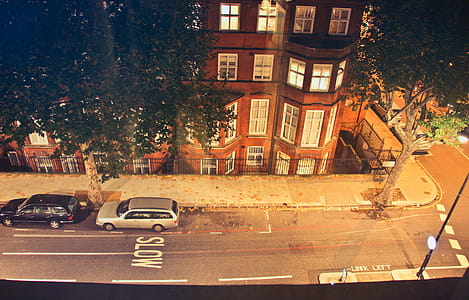 High Angle View Of Front facade of flat buildings in london with two cars parked at the road thumbnail