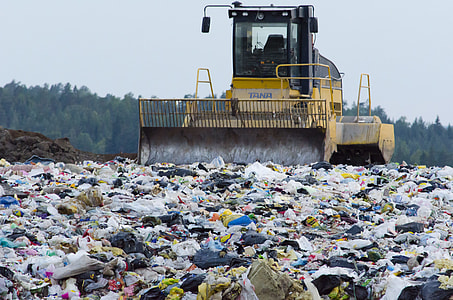 yellow and black tractor on garbage island during daytime thumbnail