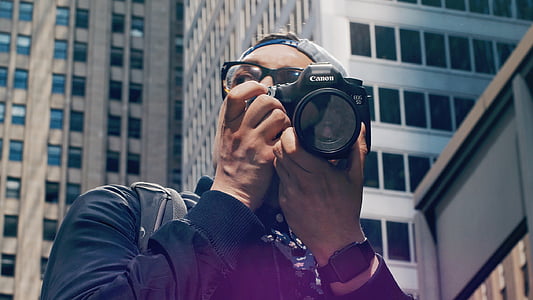 man using black Canon DSLR camera thumbnail