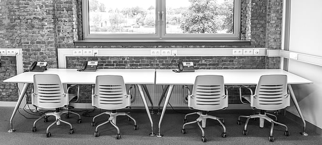 vacant four white rolling armchairs in front of rectangular white wooden table near clear glass window thumbnail