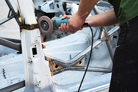 person grinding white steel using green angle grinder thumbnail