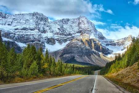 road with snow covered mountains thumbnail
