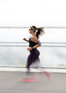 woman jogging near body of water during daytime thumbnail