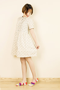 woman in beige dress standing near wall thumbnail