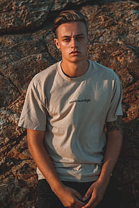 man sitting on brown rock thumbnail