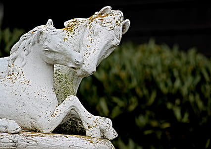 two white horse statuettes near green leafed plant thumbnail