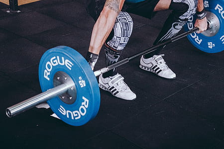 Man With Lift Stance Holds Blue Rogue Adjustable Barbell thumbnail