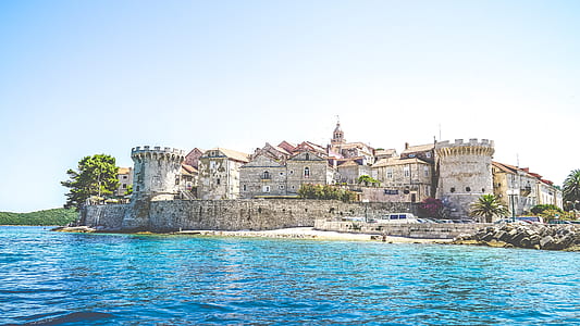gray concrete buildings near body of water during daytime thumbnail