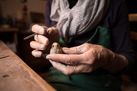 person holding a brown wooden bird thumbnail