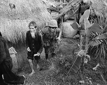 Marine from 1st Battalion, 3rd Marines, moves an alleged Viet Cong activist in Vietnam War thumbnail