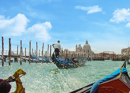 man rowing blue gondola boat at daytime thumbnail