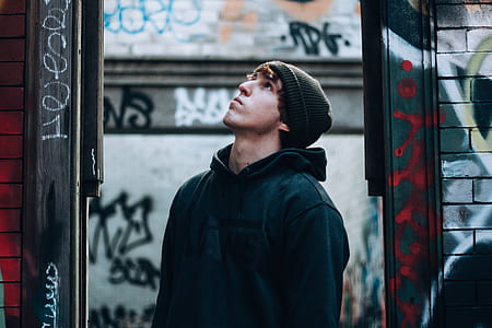 man wearing gray pullover hoodie standing looking upwards thumbnail
