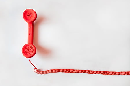 red telephone on white surface thumbnail