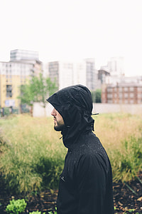 man wearing black hooded jacket near green grass at daytime thumbnail