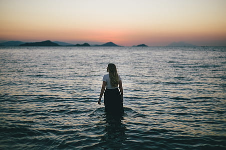 woman standing on shallow part of body of water thumbnail