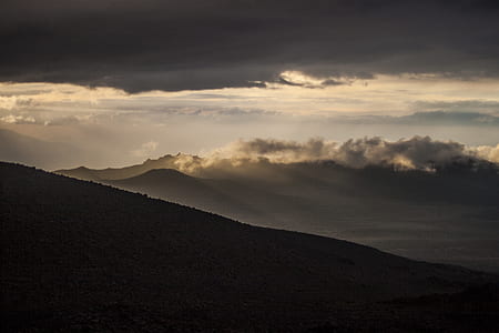 landscape photography of mountain under cloudy sky thumbnail