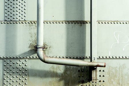 white steel pipe beside steel wall thumbnail