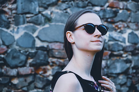 woman in sunglasses and black top near gray surface thumbnail
