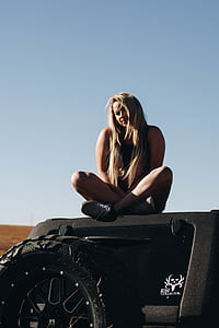 woman sitting on vehicle roof thumbnail