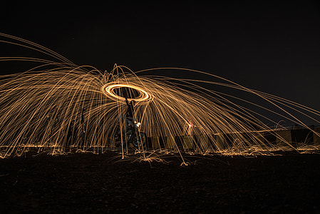 steel wool photography of man at nighttime thumbnail