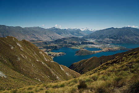 body of water within mountain range during daytime thumbnail