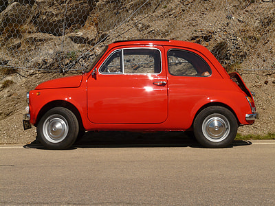 red 3-door hatchback on brown pave road thumbnail