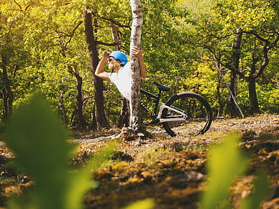 Photo of Person Wearing White T-shirt Holding Tree Trunk thumbnail