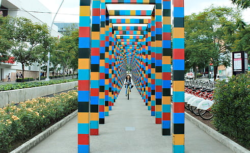 person riding bike between multicolored posts thumbnail