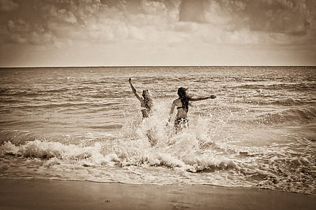 sepia photography of women on seashore thumbnail