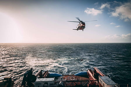 orange helicopter in mid air during daytime thumbnail