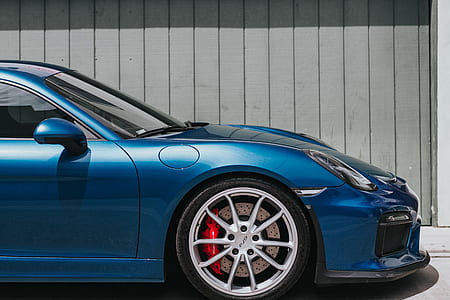 blue car parked in front of gray painted wall thumbnail