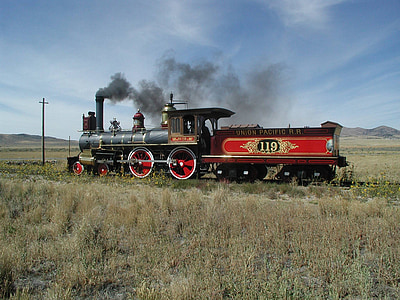 red and black locomotive train near green grass field thumbnail
