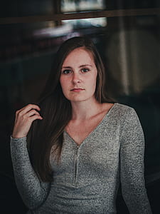 woman wearing gray long-sleeved shirt holding her hair thumbnail